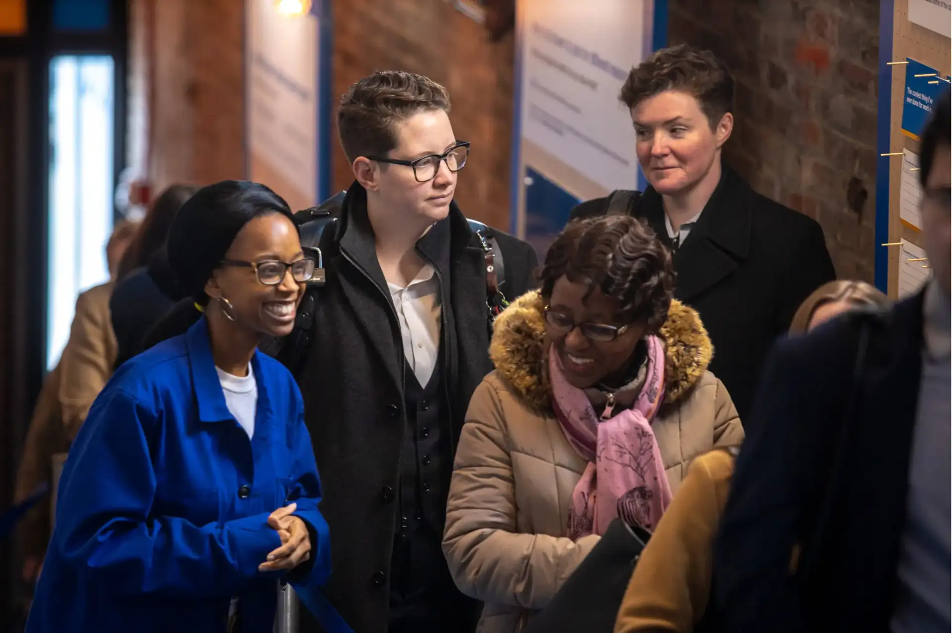 Candid photo of a group of Black and white people in business attire talking